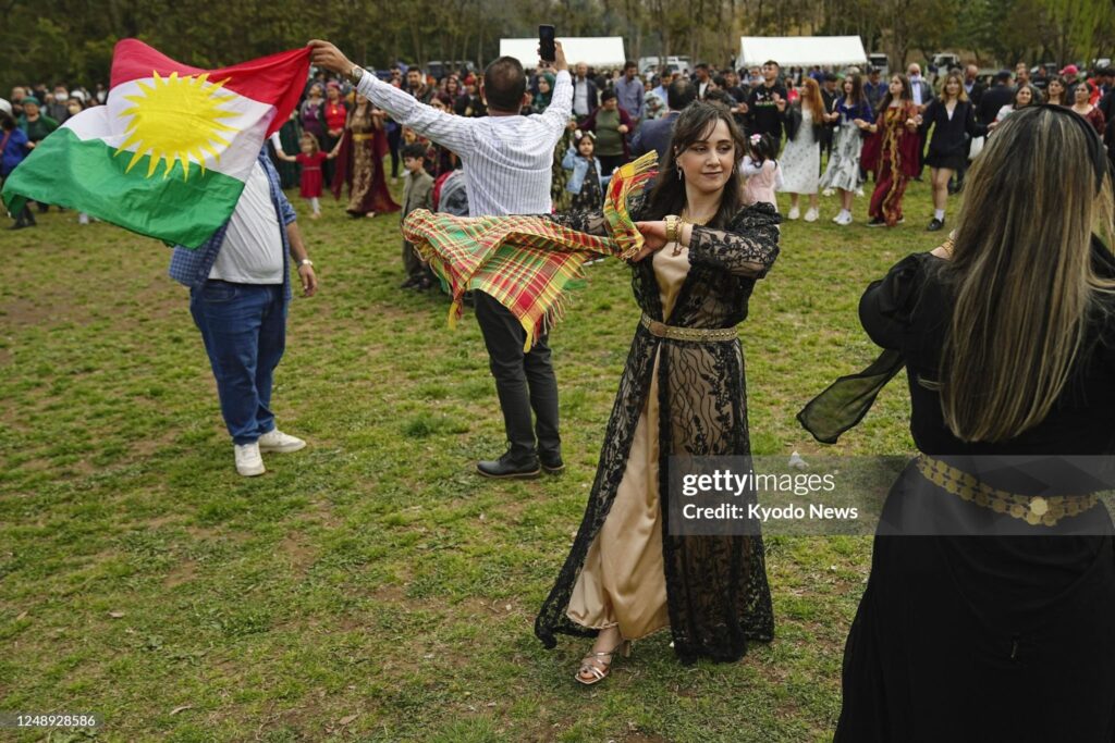 Kurdish people dance in celebration of their traditional New Year holiday of Newroz in Saitama near Tokyo on March 21, 2023. (Photo by Kyodo News via Getty Images)