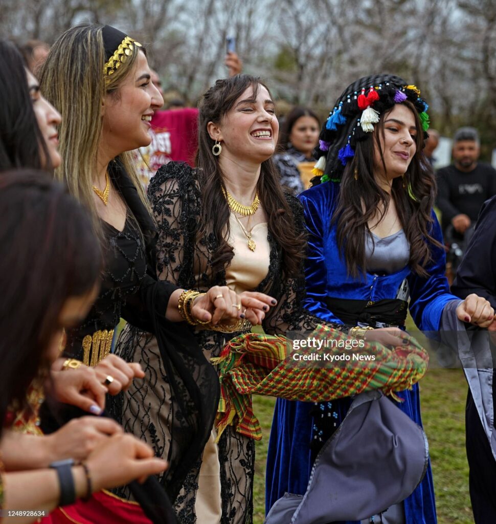 Kurdish people dance in celebration of their traditional New Year holiday of Newroz in Saitama near Tokyo on March 21, 2023. (Photo by Kyodo News via Getty Images)