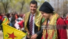 TOKYO, JAPAN - MARCH 24:  A Kurdish man holds a flag of the Kurdish People's Protection Units (YPG) as he talks with a friend during Nowruz celebrations on March 24, 2018 in Tokyo, Japan. Nowruz meaning 'new day' and marking the first day of spring, is widely celebrated by Kurdish communities around the world including in Japan where an estimated 2000 Kurds reside, many of whom are claiming refugee status owing to alleged human rights abuses in Turkey and Iraq. Although the Japanese government has issued some temporary permits allowing many to stay for years, no Turkish Kurd has ever been received refugee status in Japan, which would allow them to settle permanently.æ (Photo by Carl Court/Getty Images)
