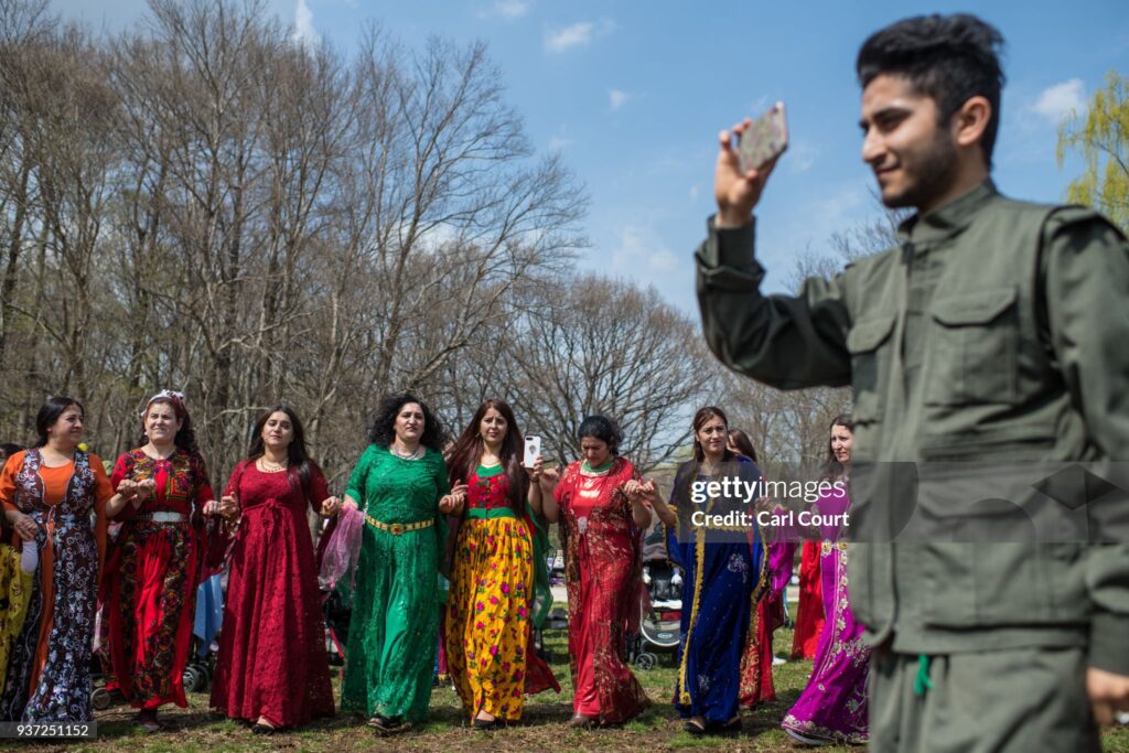 TOKYO, JAPAN - MARCH 24: A Kurdish man films with his phone as Kurdish women dance during Nowruz celebrations on March 24, 2018 in Tokyo, Japan. Nowruz meaning 'new day' and marking the first day of spring, is widely celebrated by Kurdish communities around the world including in Japan where an estimated 2000 Kurds reside, many of whom are claiming refugee status owing to alleged human rights abuses in Turkey and Iraq. Although the Japanese government has issued some temporary permits allowing many to stay for years, no Turkish Kurd has ever been received refugee status in Japan, which would allow them to settle permanently.   (Photo by Carl Court/Getty Images)