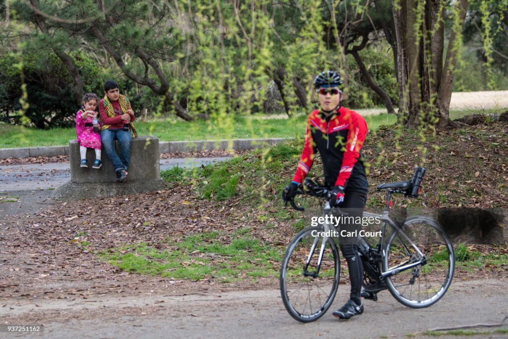 TOKYO, JAPAN - MARCH 24: A cyclist looks on while Kurdish children sit on a bollard during Nowruz celebrations on March 24, 2018 in Tokyo, Japan. Nowruz meaning 'new day' and marking the first day of spring, is widely celebrated by Kurdish communities around the world including in Japan where an estimated 2000 Kurds reside, many of whom are claiming refugee status owing to alleged human rights abuses in Turkey and Iraq. Although the Japanese government has issued some temporary permits allowing many to stay for years, no Turkish Kurd has ever been received refugee status in Japan, which would allow them to settle permanently.   (Photo by Carl Court/Getty Images)
