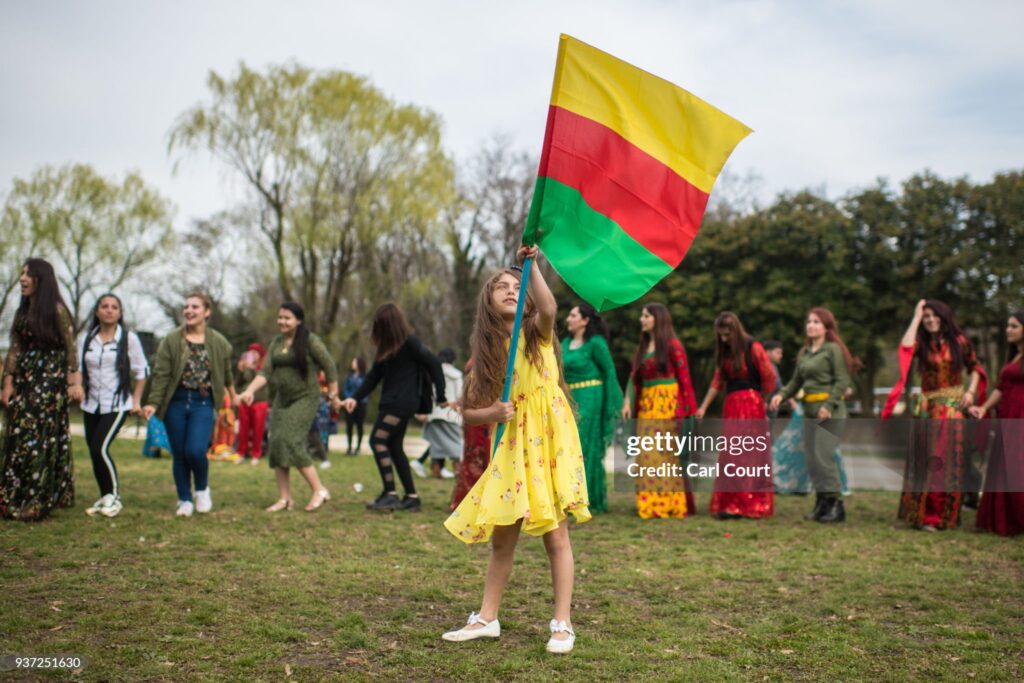 TOKYO, JAPAN - MARCH 24:  A young girl waves the flag of the Democratic Federation of Northern Syria during Nowruz celebrations on March 24, 2018 in Tokyo, Japan. Nowruz meaning 'new day' and marking the first day of spring, is widely celebrated by Kurdish communities around the world including in Japan where an estimated 2000 Kurds reside, many of whom are claiming refugeeæstatus owing to alleged human rights abuses in Turkey and Iraq. Although the Japanese government has issued some temporary permits allowing many to stay for years, no Turkish Kurd has ever been received refugee status in Japan, which would allow them to settle permanently.æ  (Photo by Carl Court/Getty Images)