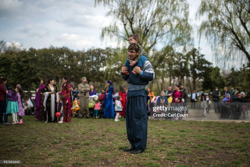TOKYO, JAPAN - MARCH 24:  A Kurdish man in traditional attire carries a child on his shoulders as he looks on during Nowruz celebrations on March 24, 2018 in Tokyo, Japan. Nowruz meaning 'new day' and marking the first day of spring, is widely celebrated by Kurdish communities around the world including in Japan where an estimated 2000 Kurds reside, many of whom are claiming refugeeæstatus owing to alleged human rights abuses in Turkey and Iraq. Although the Japanese government has issued some temporary permits allowing many to stay for years, no Turkish Kurd has ever been received refugee status in Japan, which would allow them to settle permanently.  (Photo by Carl Court/Getty Images)