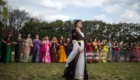 TOKYO, JAPAN - MARCH 24:  A Kurdish woman in traditional dress walks past friends as they dance during Nowruz celebrations on March 24, 2018 in Tokyo, Japan. Nowruz meaning 'new day' and marking the first day of spring, is widely celebrated by Kurdish communities around the world including in Japan where an estimated 2000 Kurds reside, many of whom are claiming refugeeæstatus owing to alleged human rights abuses in Turkey and Iraq. Although the Japanese government has issued some temporary permits allowing many to stay for years, no Turkish Kurd has ever been received refugee status in Japan, which would allow them to settle permanently.  (Photo by Carl Court/Getty Images)